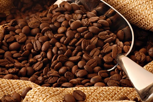 Uma colher de café em grãos da marca Café Damasco.