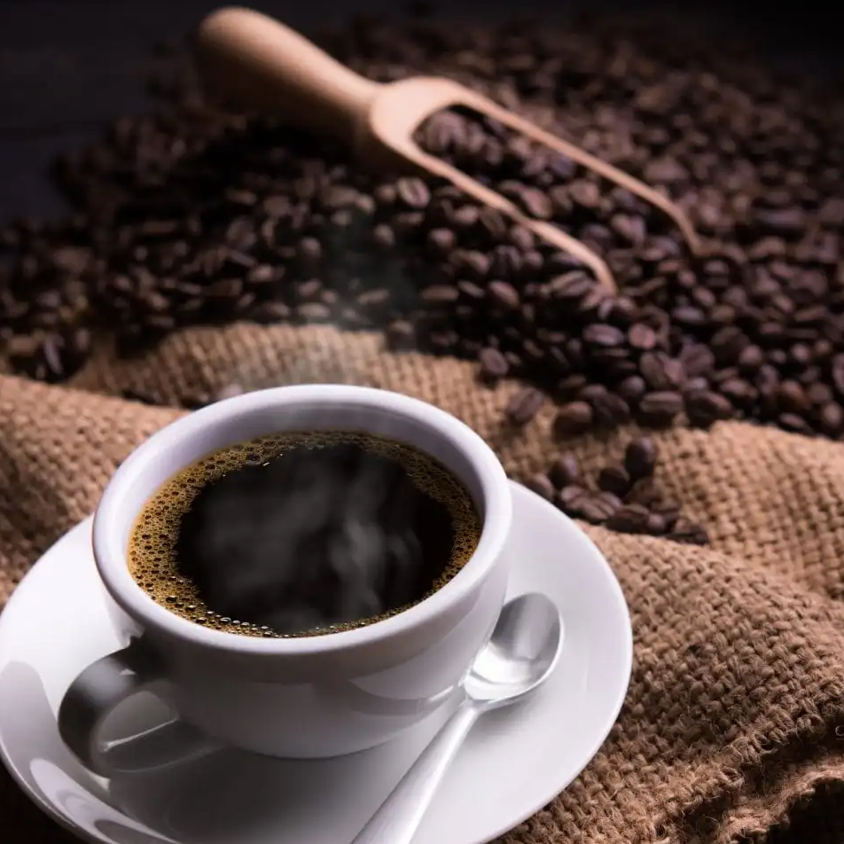 Uma xícara de café com grãos de café e uma concha de madeira